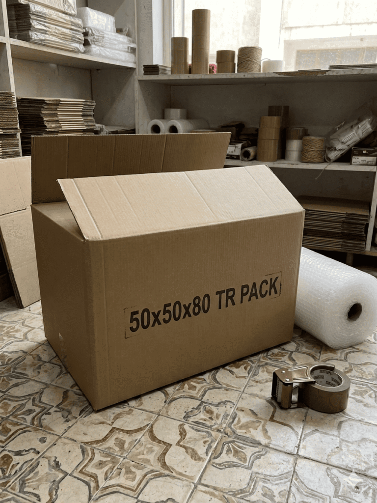 كرتونة 50×80×50 سم 5 طبقات موضوعة أمام رصات الكراتين داخل مخزن TR Pack